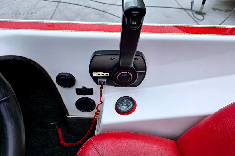Slide: The Image of 1998 Champion 187 DLX Elite boat control panel with throttle lever and red seat. - 24