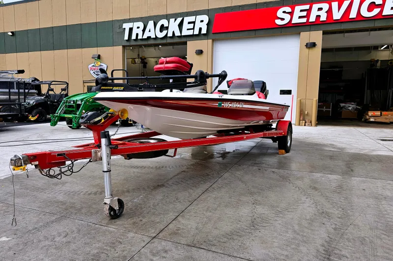 Slide: The Image of 1998 Champion 187 DLX Elite boat on red trailer outside Tracker service center. - 5