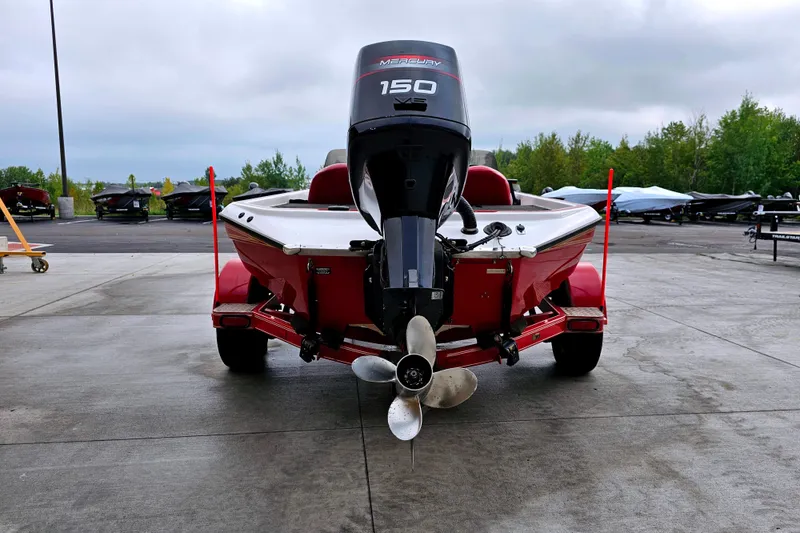 Slide: The Image of 1998 Champion 187 DLX Elite boat with Mercury 150 engine, parked outdoors. - 7