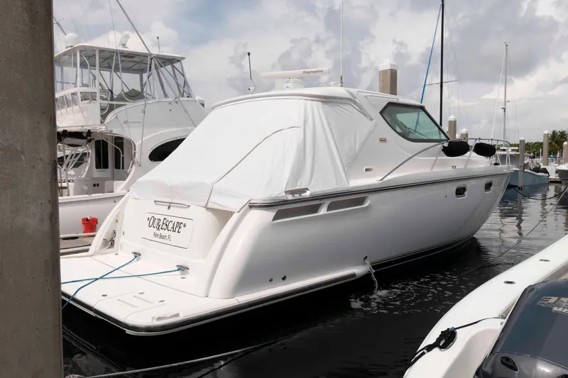 Slide: The Image of 2007 Tiara Yachts 4300 Sovran docked at marina, covered, with cloudy sky. - 2