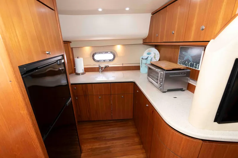 Slide: The Image of 2007 Tiara Yachts 4300 Sovran galley with wood cabinetry and modern appliances. - 24