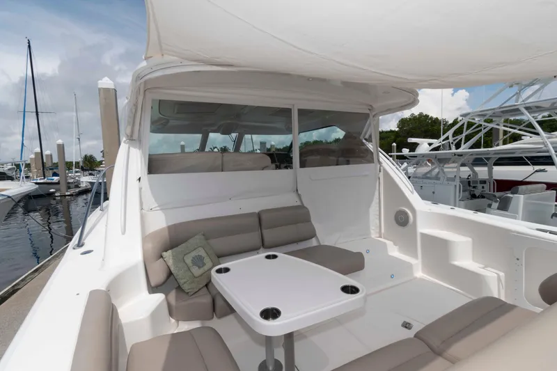 Slide: The Image of 2007 Tiara Yachts 4300 Sovran with spacious seating and table in marina setting. - 8