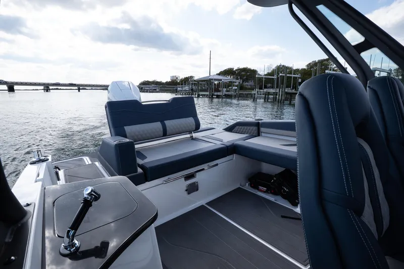Slide: The Image of 2026 Monterey Elite 27 OB boat interior with luxurious seating and scenic waterfront view. - 10