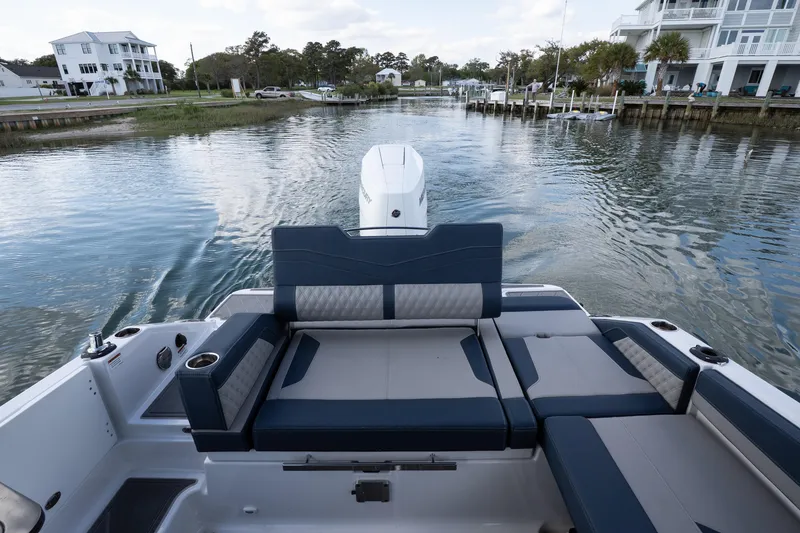 Slide: The Image of 2026 Monterey Elite 27 OB boat interior with luxurious seating on a serene waterway. - 17