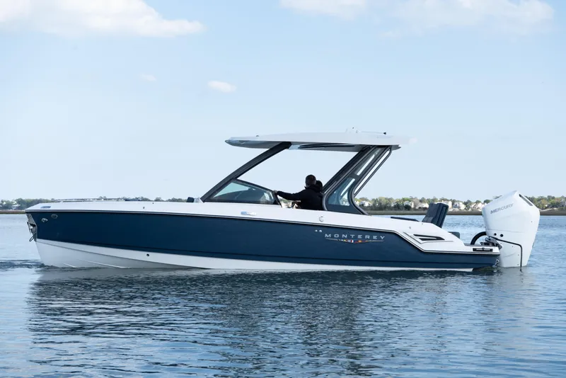 Slide: The Image of 2026 Monterey Elite 27 OB boat cruising on calm water under a clear sky. - 3