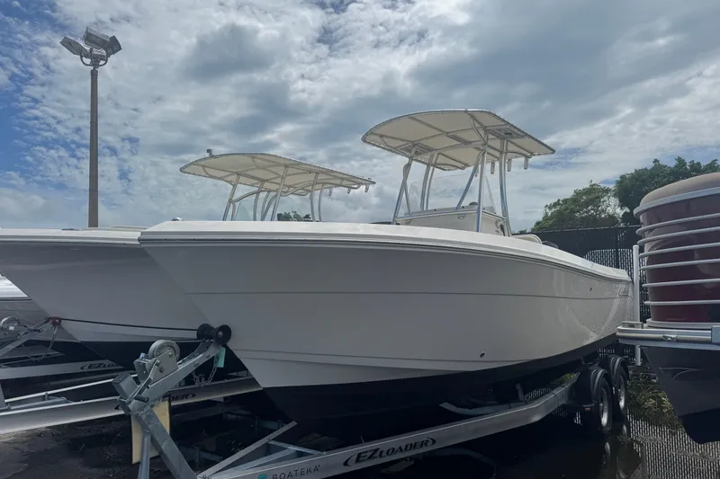 The Image of 2022 Cobia 237 Center Console boat on trailer under cloudy sky. - 0