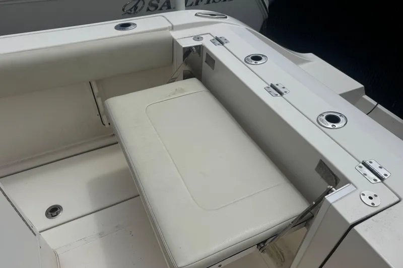 Slide: The Image of 2022 Cobia 237 Center Console boat with white seating and rod holders. - 9