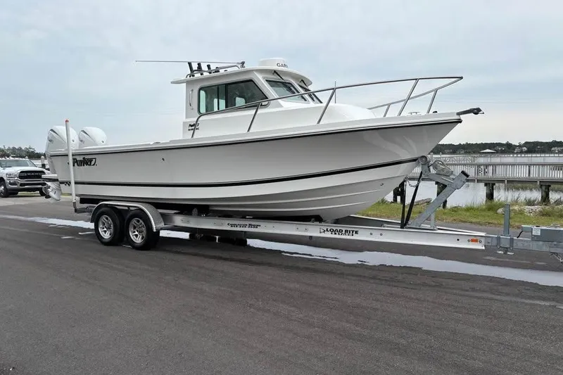 The Image of 2026 Parker 2420 Sport Cabin boat on trailer by waterfront. - 0