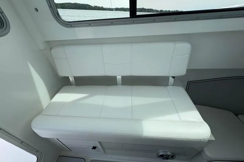 Slide: The Image of 2026 Parker 2420 Sport Cabin interior with white cushioned seating and window view. - 12