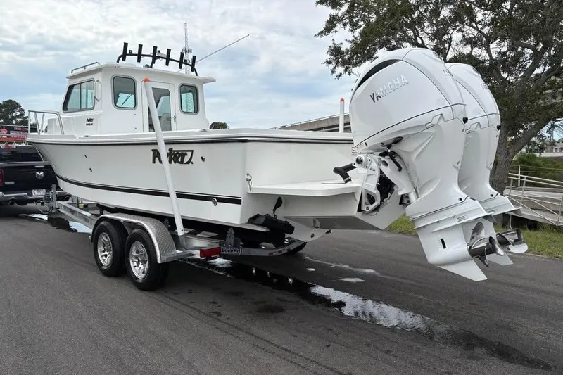Slide: The Image of 2026 Parker 2420 Sport Cabin boat on trailer with twin Yamaha engines. - 3
