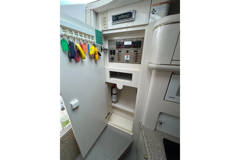 Slide: The Image of 2000 Maxum 3000 SCR boat interior control panel with key storage and fire extinguisher. - 14