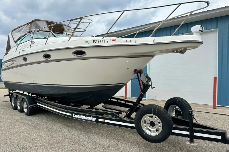 Slide: The Image of 2000 Maxum 3000 SCR boat on a Loadmaster trailer, parked outdoors. - 36