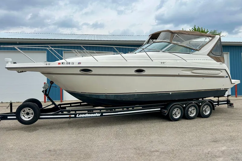 Slide: The Image of 2000 Maxum 3000 SCR boat on trailer, parked outside blue building. - 37