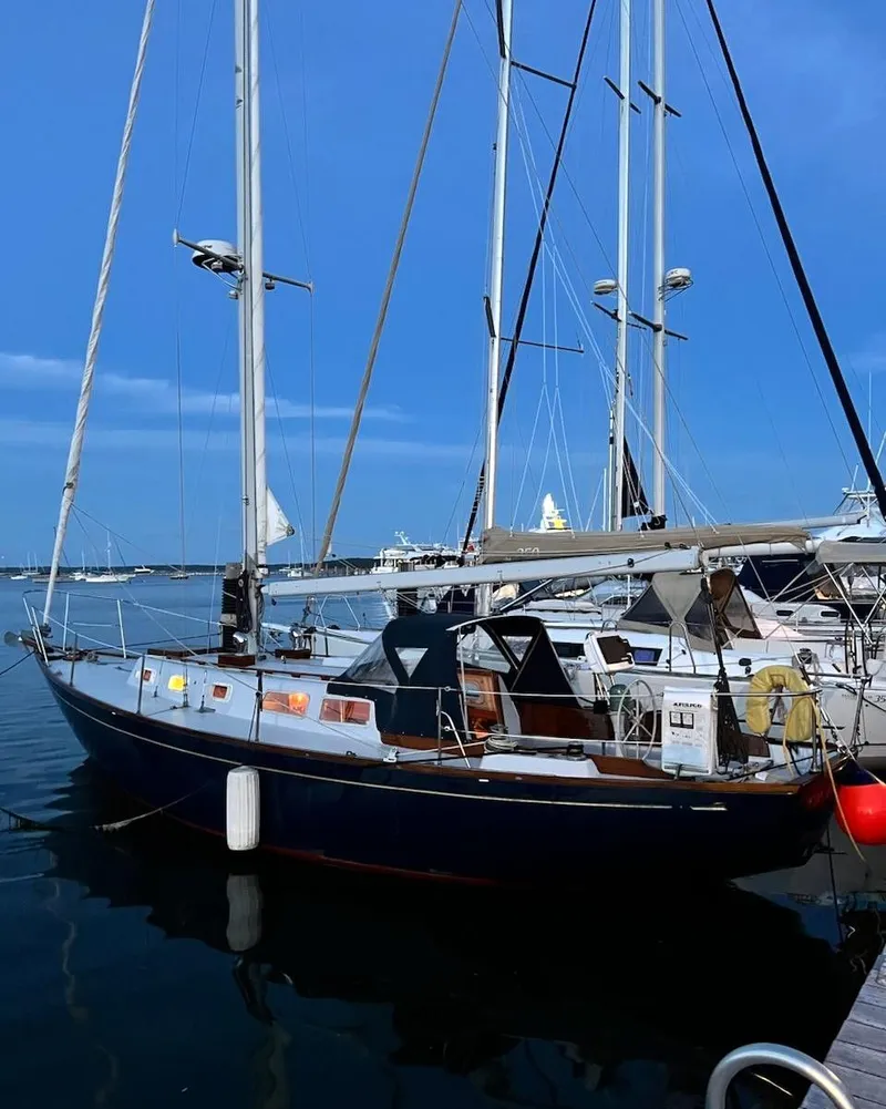Slide: The Image of 1967 Jensen Cal 36 sailboat docked at marina under clear blue sky. - 2