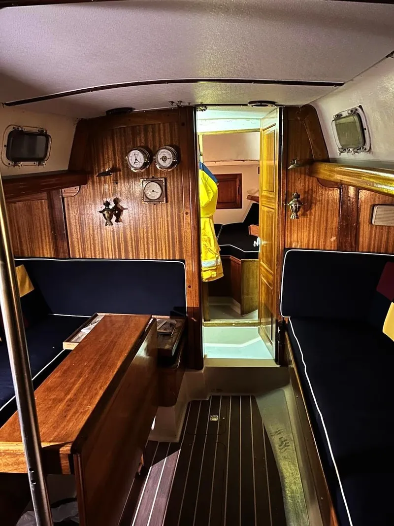 Slide: The Image of Interior of a 1967 Jensen Cal 36 sailboat with wooden paneling and nautical decor. - 14