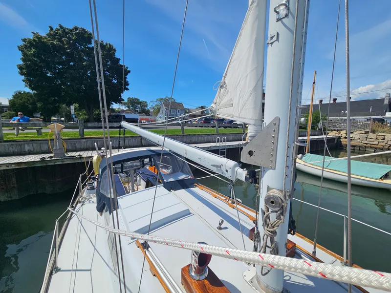 Slide: The Image of 1967 Jensen Cal 36 sailboat docked, showcasing mast and rigging under clear blue sky. - 7