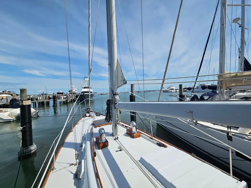 Slide: The Image of 1967 Jensen Cal 36 sailboat docked at a marina under a clear blue sky. - 4