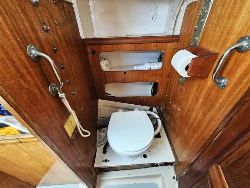 Slide: The Image of 1967 Jensen Cal 36 boat bathroom with wooden paneling and compact toilet. - 20