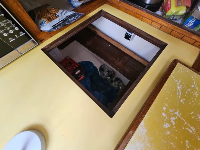 Slide: The Image of Hidden storage compartment in 1967 Jensen Cal 36 boat galley, with snacks and supplies. - 31