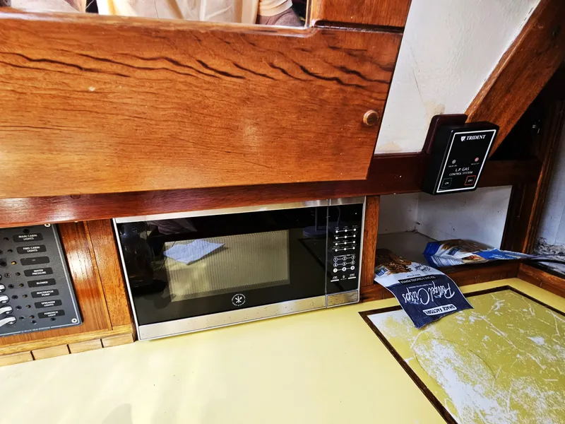 Slide: The Image of 1967 Jensen Cal 36 interior with microwave and control panel in wooden cabinetry. - 25