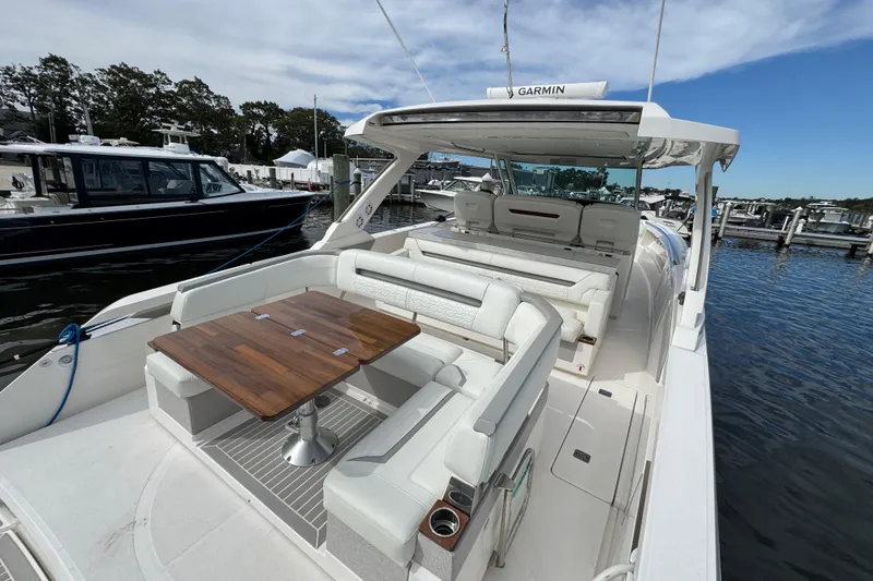 Slide: The Image of 2023 Tiara Yachts 43 LS luxury boat with elegant seating and wooden table on deck. - 21