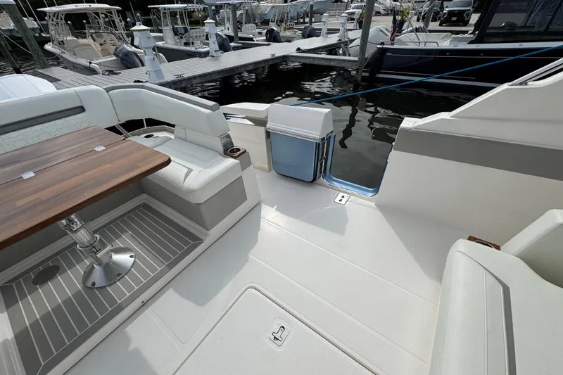 Slide: The Image of 2023 Tiara Yachts 43 LS interior with seating and table, docked at marina. - 23
