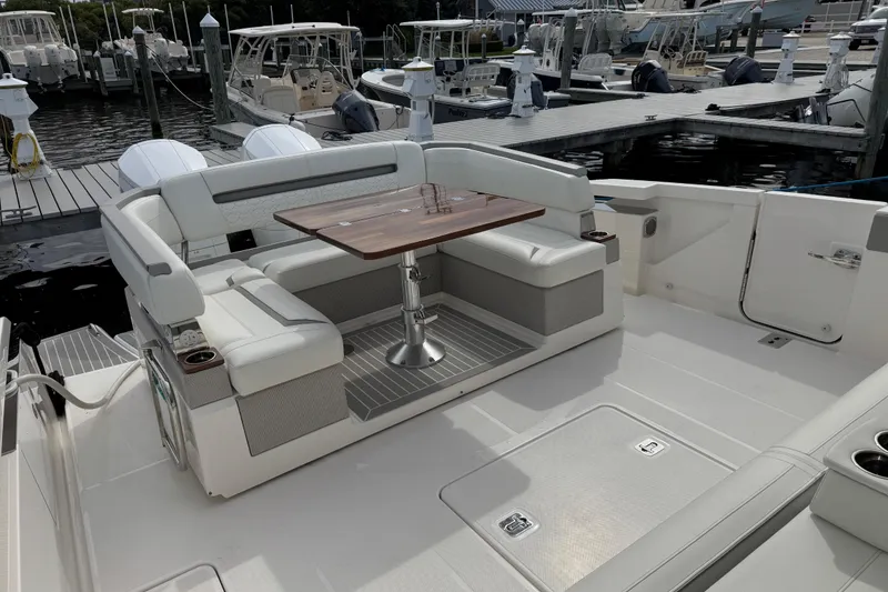 Slide: The Image of 2023 Tiara Yachts 43 LS with elegant seating and table, docked at marina. - 25