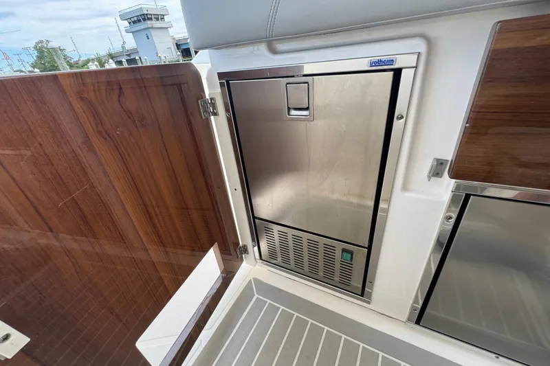 Slide: The Image of 2023 Tiara Yachts 43 LS interior with stainless steel appliance and wooden paneling. - 34