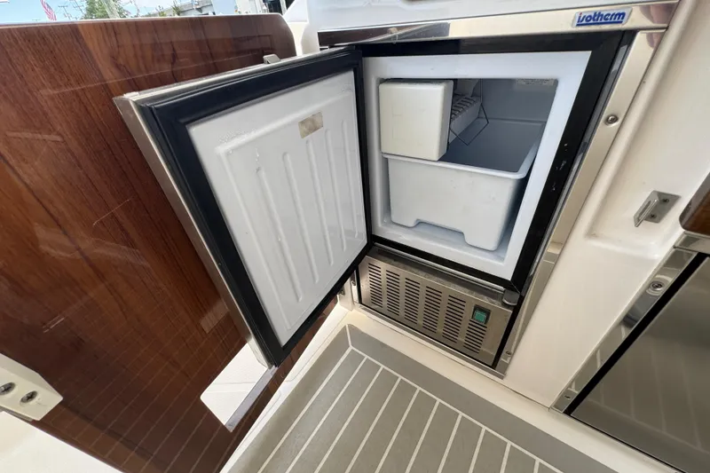 Slide: The Image of Open refrigerator on 2023 Tiara Yachts 43 LS, showcasing interior storage space. - 35