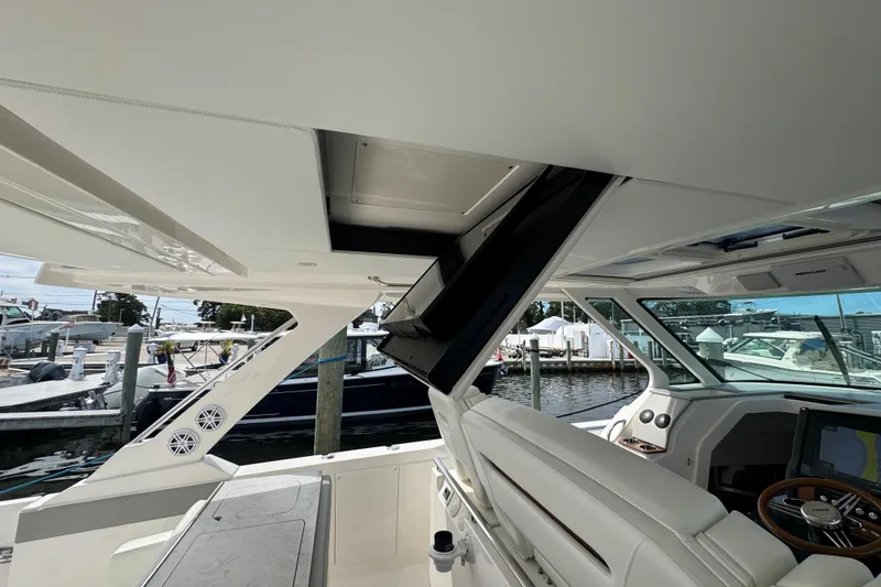 Slide: The Image of 2023 Tiara Yachts 43 LS interior with helm, seating, and marina view. - 44