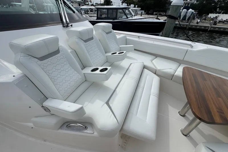 Slide: The Image of 2023 Tiara Yachts 43 LS interior with luxurious white seating and wooden table. - 62