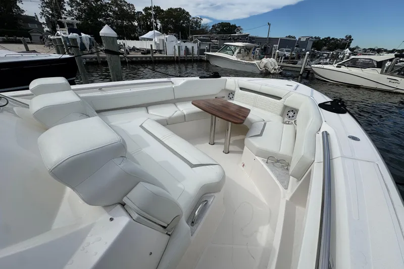 Slide: The Image of 2023 Tiara Yachts 43 LS boat with white seating and wooden table in marina. - 68
