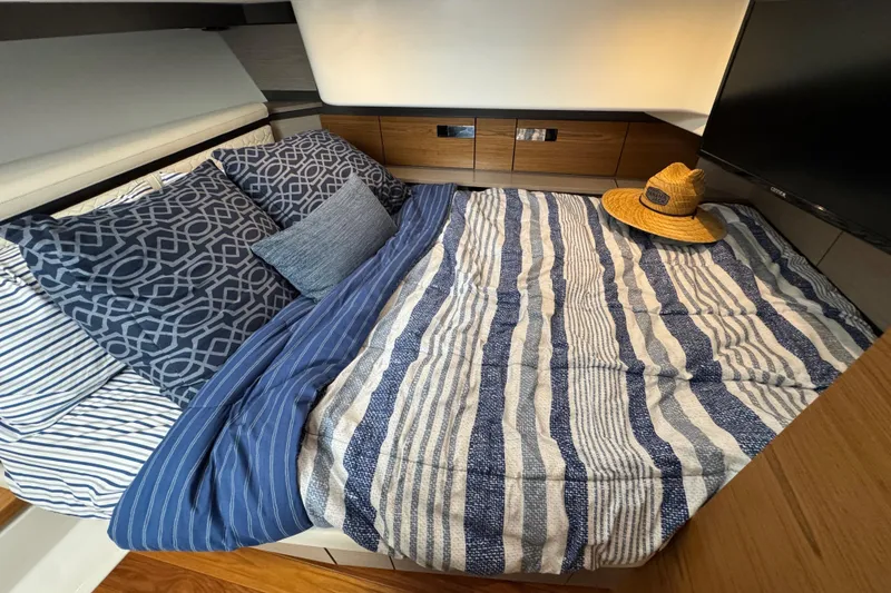 Slide: The Image of Luxurious cabin interior of 2023 Tiara Yachts 43 LS with striped bedding and hat. - 71