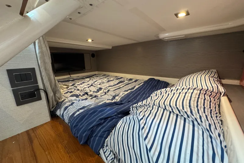 Slide: The Image of Cozy cabin interior of 2023 Tiara Yachts 43 LS with striped bedding and modern lighting. - 74