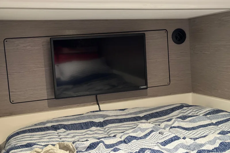 Slide: The Image of Interior of 2023 Tiara Yachts 43 LS with TV and striped bedding. - 75