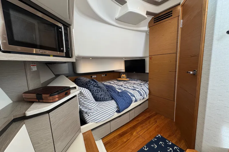 Slide: The Image of Luxurious 2023 Tiara Yachts 43 LS cabin interior with bed, microwave, and TV. - 76