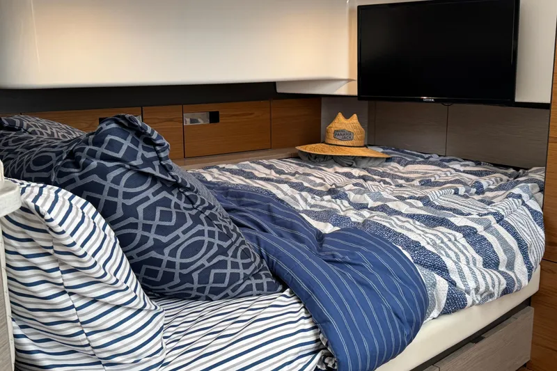 Slide: The Image of Luxurious bedroom interior of 2023 Tiara Yachts 43 LS with striped bedding and TV. - 77