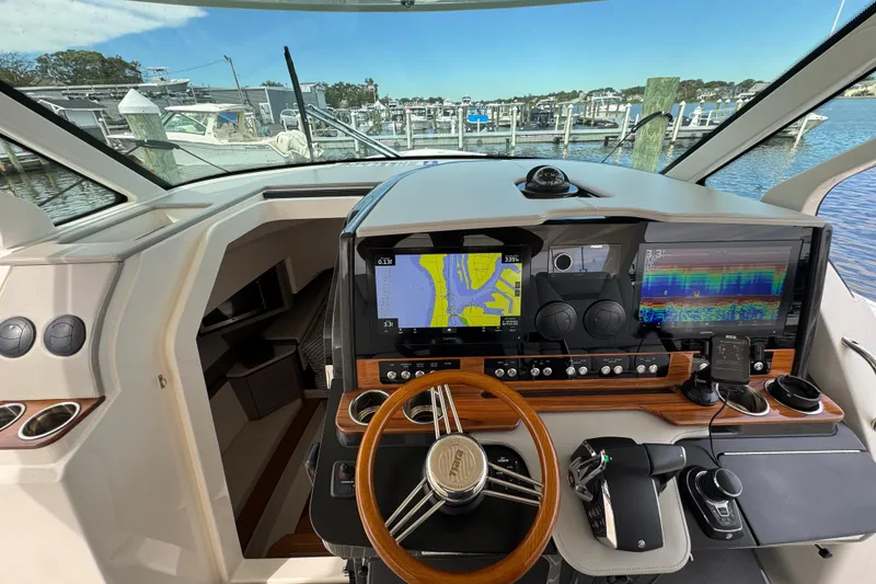 Slide: The Image of 2023 Tiara Yachts 43 LS helm with advanced navigation displays and controls at marina. - 83