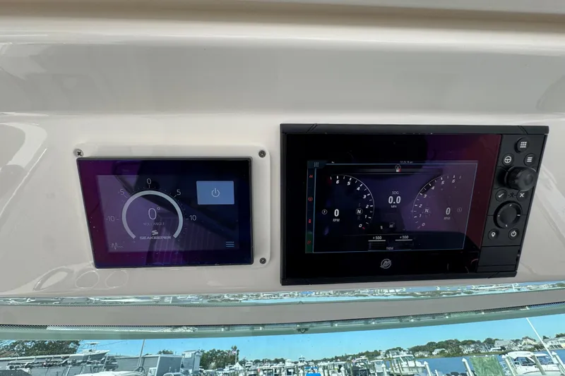 Slide: The Image of 2023 Tiara Yachts 43 LS dashboard with digital displays and navigation controls. - 85
