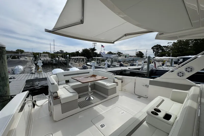 Slide: The Image of 2023 Tiara Yachts 43 LS luxury boat interior with seating and table at marina. - 9