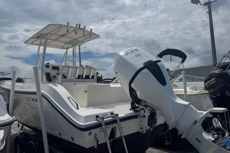 Slide: The Image of 2022 Cobia 237 Center Console boat with Honda 225 engine, docked under cloudy sky. - 4