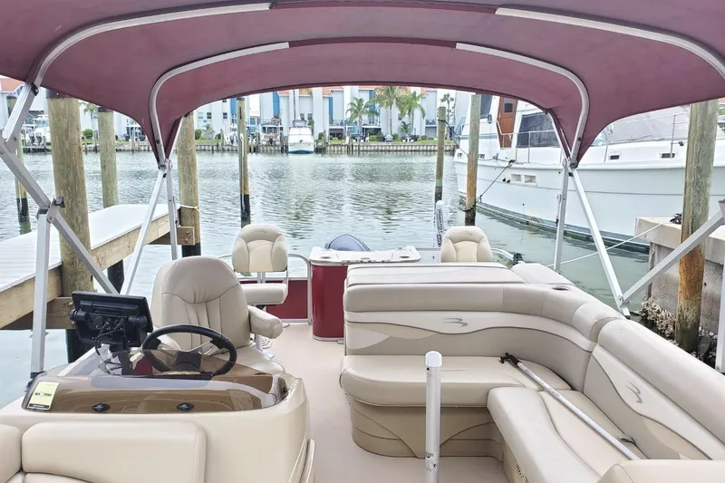 Slide: The Image of 2012 Bennington 22 SSI pontoon boat with Yamaha motor on a sandy shore. - 2