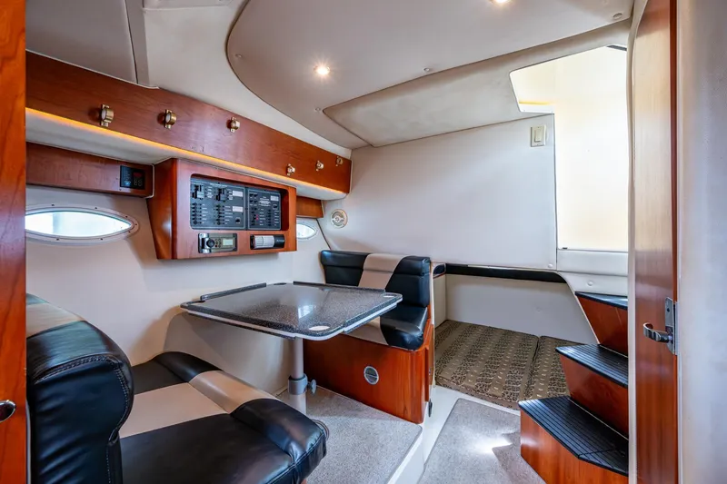 Slide: The Image of 2002 Sport-Craft 3150 Sportfish cabin interior with seating, table, and control panel. - 12