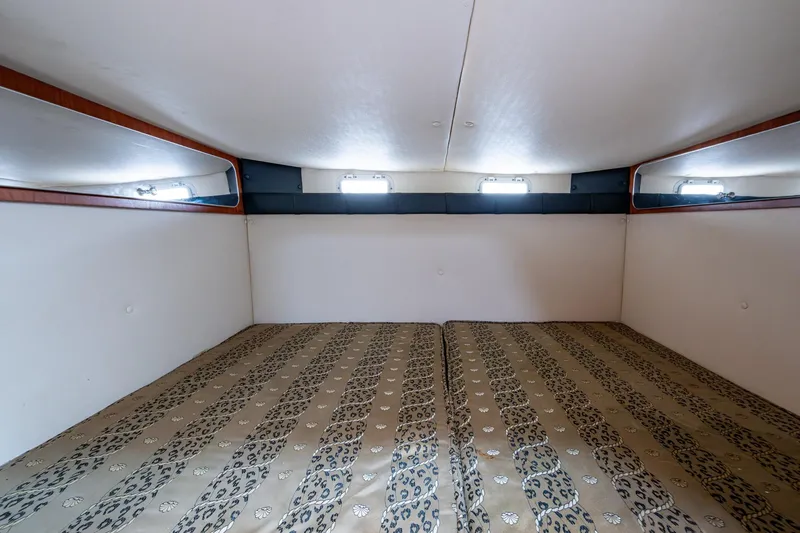 Slide: The Image of Interior cabin of 2002 Sport-Craft 3150 Sportfish with patterned bedding and windows. - 16