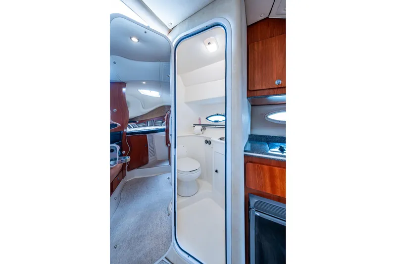 Slide: The Image of Interior of 2002 Sport-Craft 3150 Sportfish boat, featuring a compact bathroom and wooden cabinetry. - 17