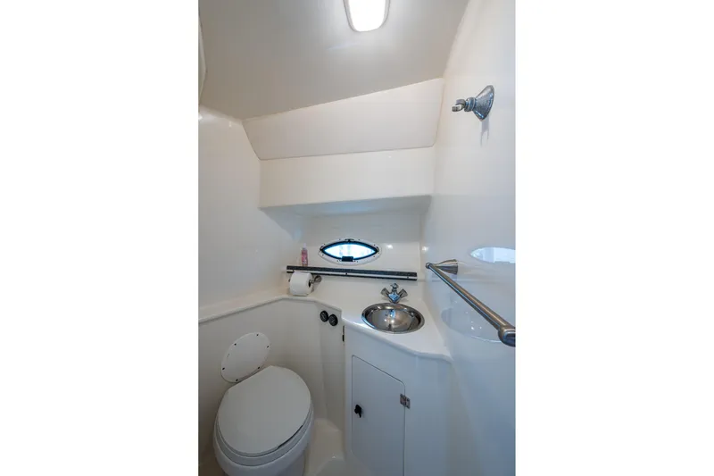 Slide: The Image of 2002 Sport-Craft 3150 Sportfish boat bathroom with toilet, sink, and porthole window. - 18