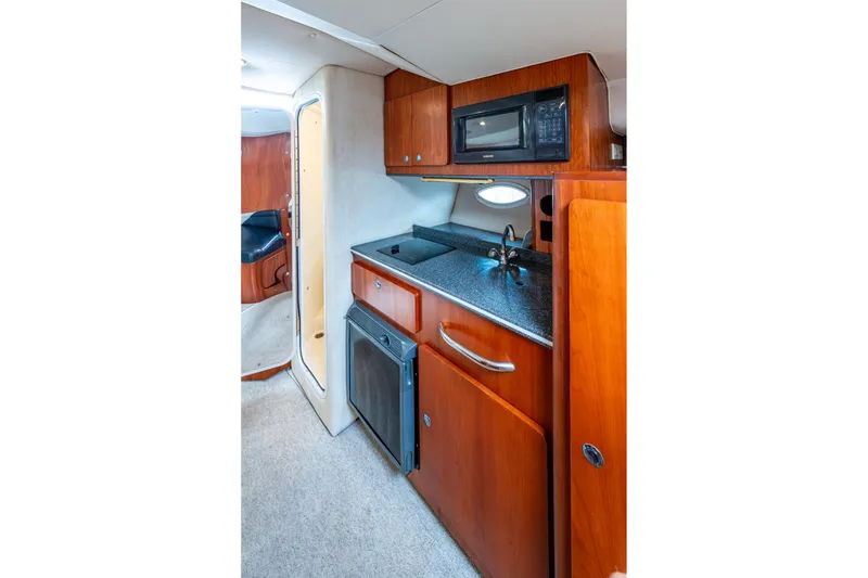 Slide: The Image of 2002 Sport-Craft 3150 Sportfish interior kitchen with microwave, sink, and wooden cabinetry. - 19