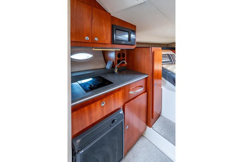 Slide: The Image of 2002 Sport-Craft 3150 Sportfish interior kitchen with wood cabinets, stove, and microwave. - 20