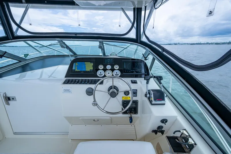 Slide: The Image of 2002 Sport-Craft 3150 Sportfish boat helm with navigation instruments and steering wheel. - 22