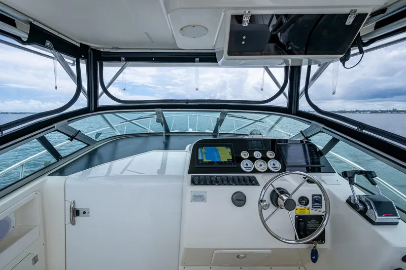 Slide: The Image of 2002 Sport-Craft 3150 Sportfish helm with navigation instruments and steering wheel on open water. - 23